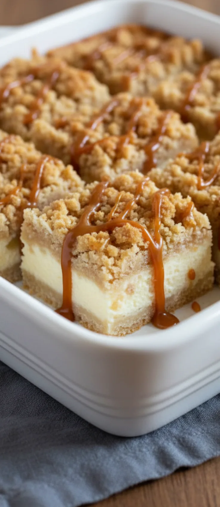 Squares of caramel apple cheesecake bars on dessert plates with extra caramel drizzle.