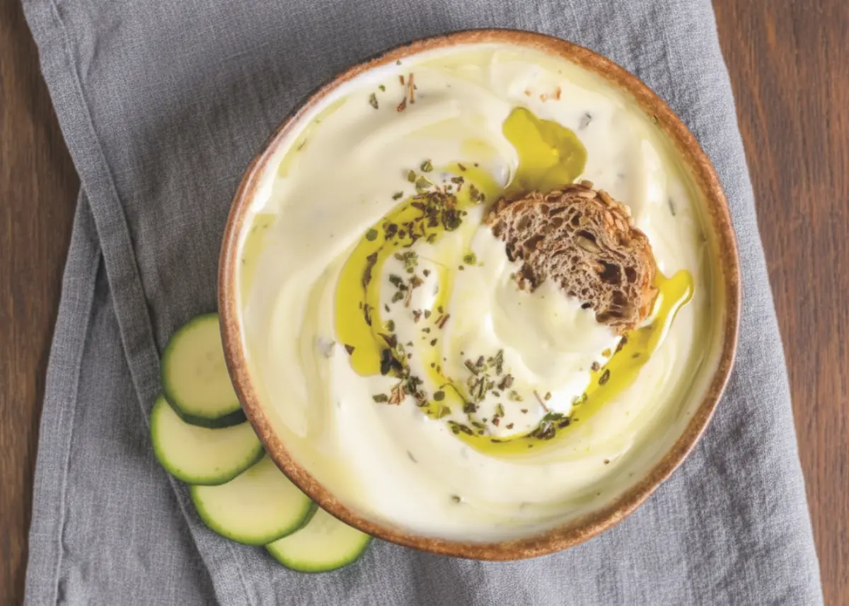 high-protein cottage cheese protein dip (3 ingredients) with olive oil swirl in a bowl, overhead, with veggie slices