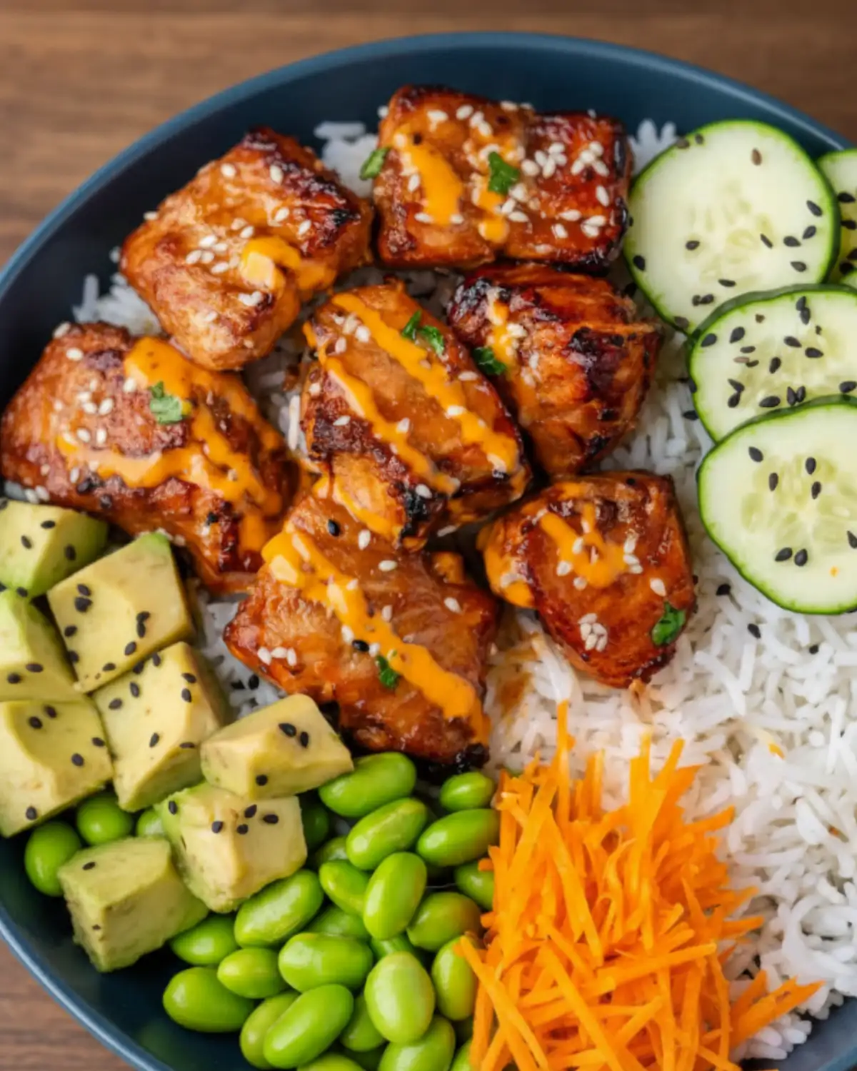 20-minute salmon veggie bowl with caramelized salmon bites, rice, avocado, cucumbers, edamame, and shredded carrots