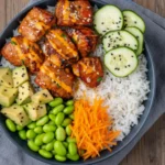 20-minute salmon veggie bowl with caramelized salmon bites, rice, avocado, cucumbers, edamame, and shredded carrots