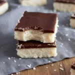 No-Bake Coconut Chocolate Bars (Rich & Simple) 2 Bite taken from coconut chocolate bar
