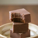 Closeup of creamy chocolate fudge mixture being spread in a pan