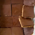 square chocolate peanut butter bars on parchment paper